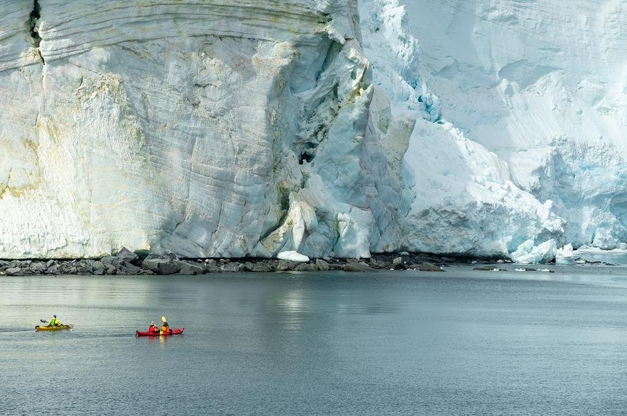 Kayakers Beneath the Glacier — Svalbard, Arctic Norway — Fine art canvas print by Naomi McLeod