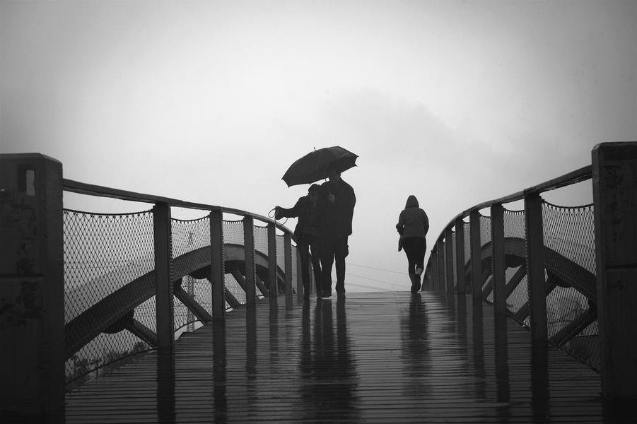 Into the Mist — Figures on Bridge in Rain — Fine art canvas print by Naomi McLeod