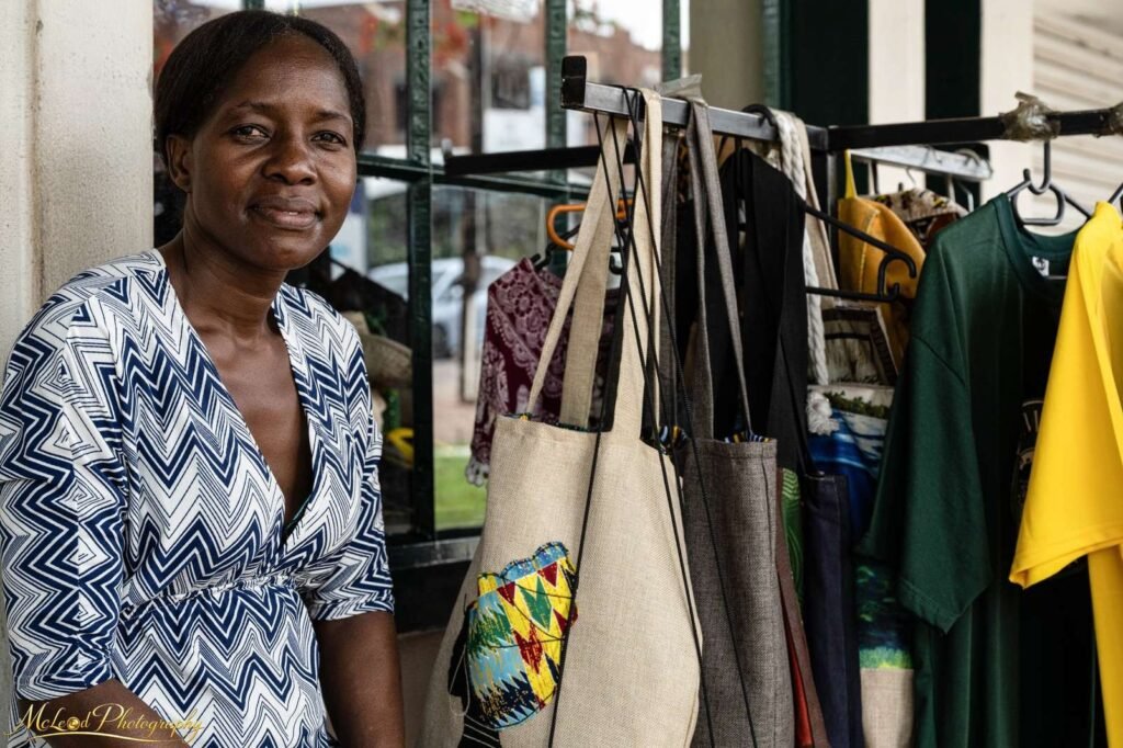 African Artisan with Handcrafted Bags at Local Market — Fine art canvas print by Naomi McLeod