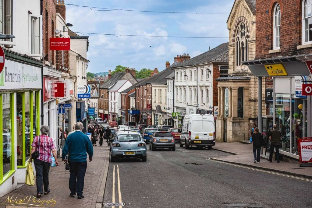Busy British High Street Market Town Daily Life Scene — Fine art canvas print by Naomi McLeod