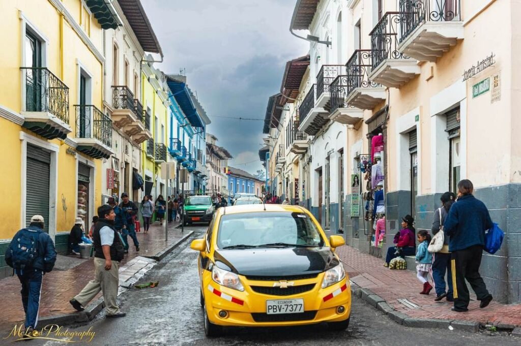 Colorful Colonial Street Scene in Ecuador with Yellow Taxi — Fine art canvas print by Naomi McLeod