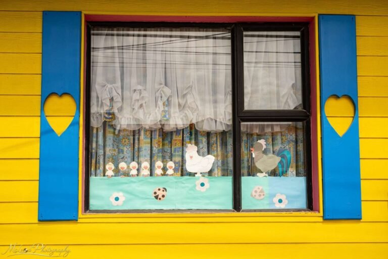 Charming Yellow Wooden House Window with Heart Shutters