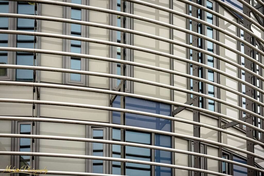 Modern Curved Building Facade with Steel Horizontal Lines — Fine art canvas print by Naomi McLeod