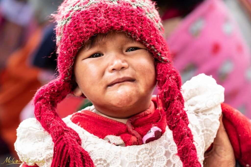 Adorable Peruvian Child in Traditional Red Knit Hat — Fine art canvas print by Naomi McLeod