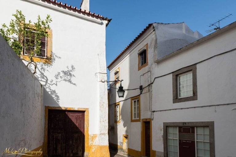 Sun-Drenched Portuguese Village Street with Yellow Trim