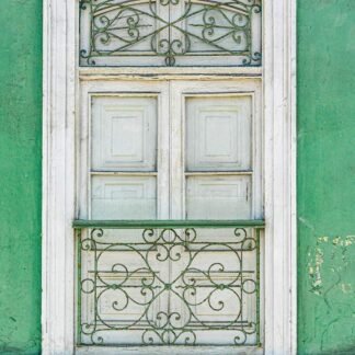Colonial Window with Ornate Ironwork on Green Wall