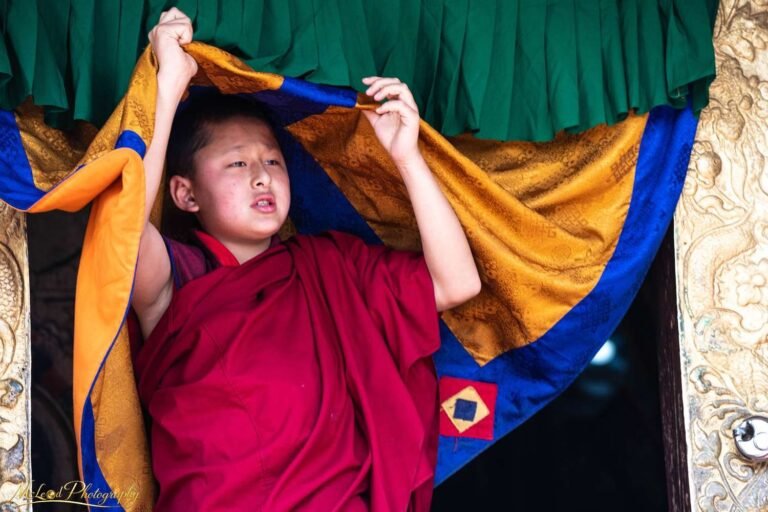 Young Buddhist Monk Emerging Through Temple Curtains Bhutan
